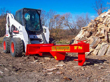 The splitter is attached to a skid steer loader and has a black metal frame with red hydraulic hoses and a control panel. The text “LAM. SKID SPLITTER 30″ Pro” is written in white on the side of the splitter.